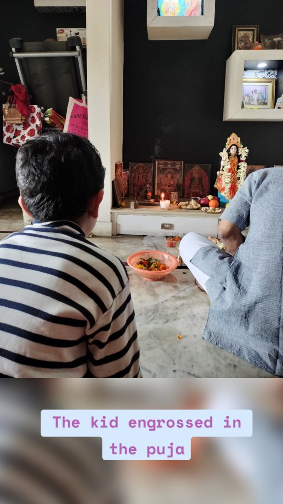 The kid engrossed in the puja